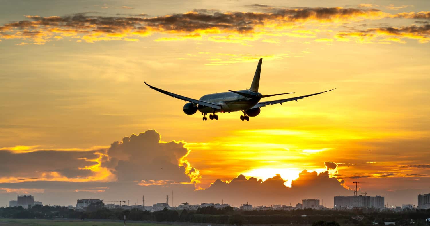 airplane flying into sunset