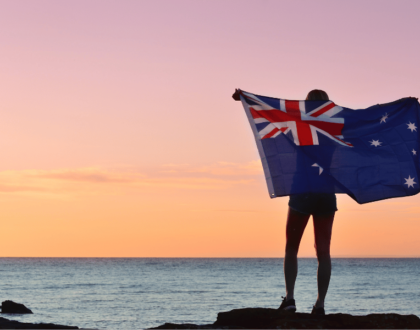 Moving to Australia - lady holding australian flag on a beach