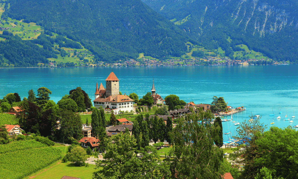 Castle by a lake with mountains in Switzerland.