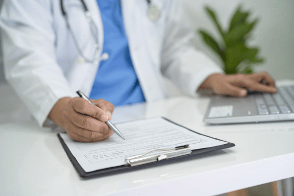 Doctor completing a health insurance form