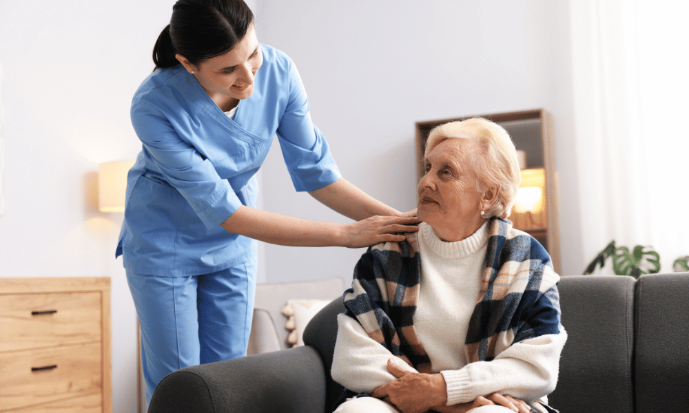 Nurse providing care and comfort to an elderly woman in a living room
