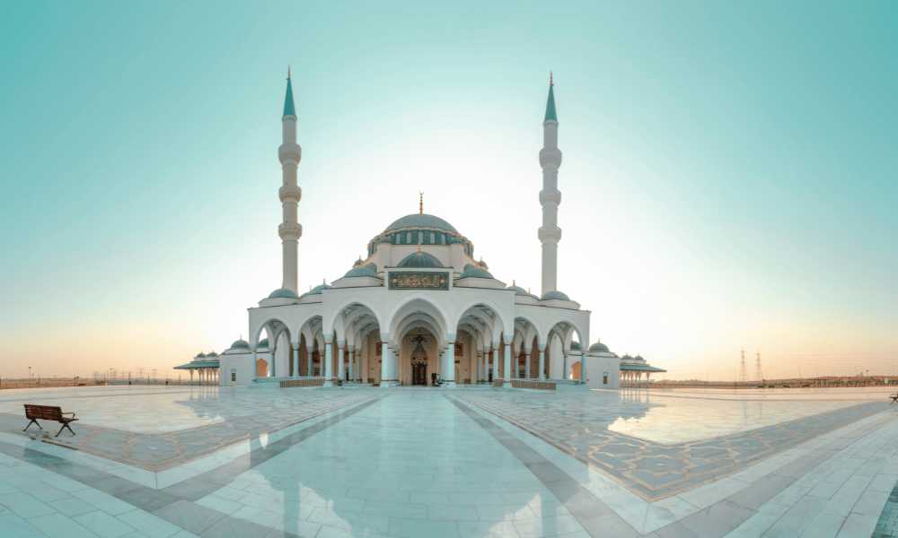 view of Sharjah Mosque in Dubai at sunrise with clear blue sky