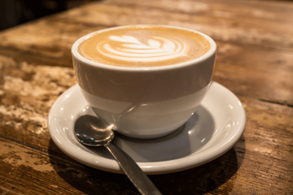 Cup of coffee with latte art on a wooden table in Melbourne café