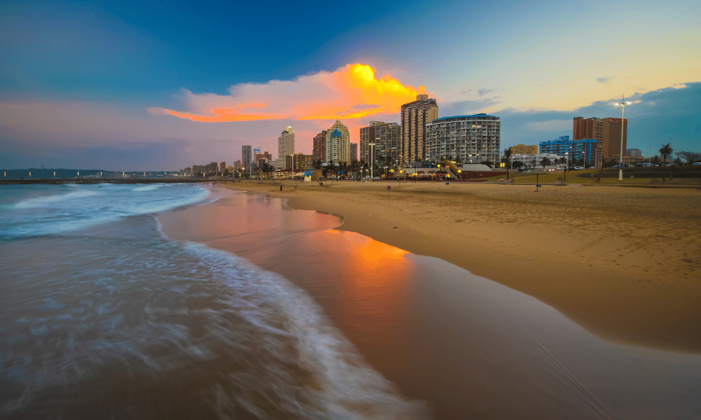 Image 1: Durban beachfront at sunset with city skyline and waves.